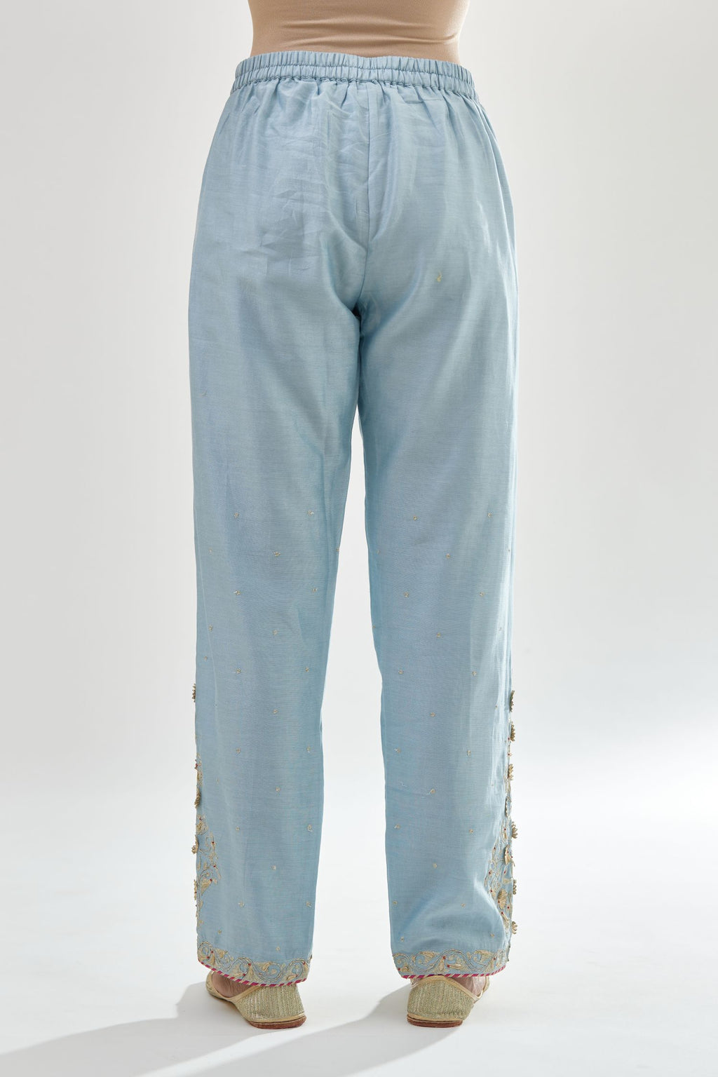 Blue silk chanderi straight pants, hem is detailed with zari, dori and gota embroidered boota at sides.