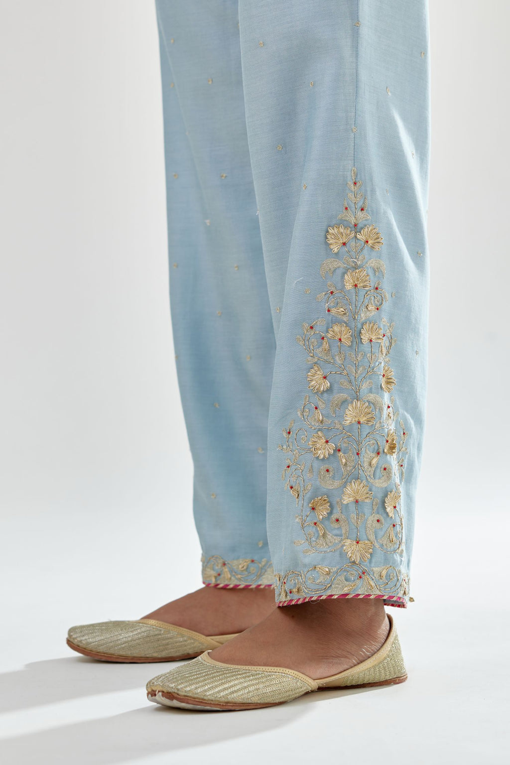 Blue silk chanderi straight pants, hem is detailed with zari, dori and gota embroidered boota at sides.