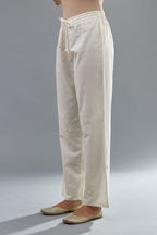 Off white cotton straight pants with all-over applique, highlighted with sequins work.