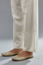 Off white cotton straight pants with all-over applique, highlighted with sequins work.