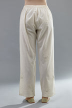 Off white cotton straight pants with all-over applique, highlighted with sequins work.