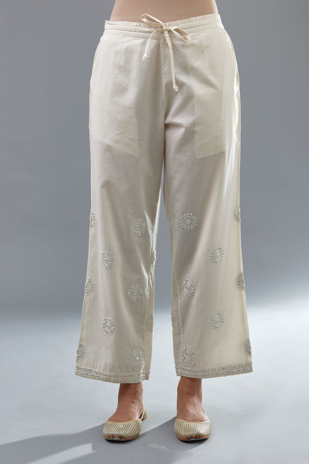 Off white cotton straight pants with all-over off white thread and mirror embroidery.