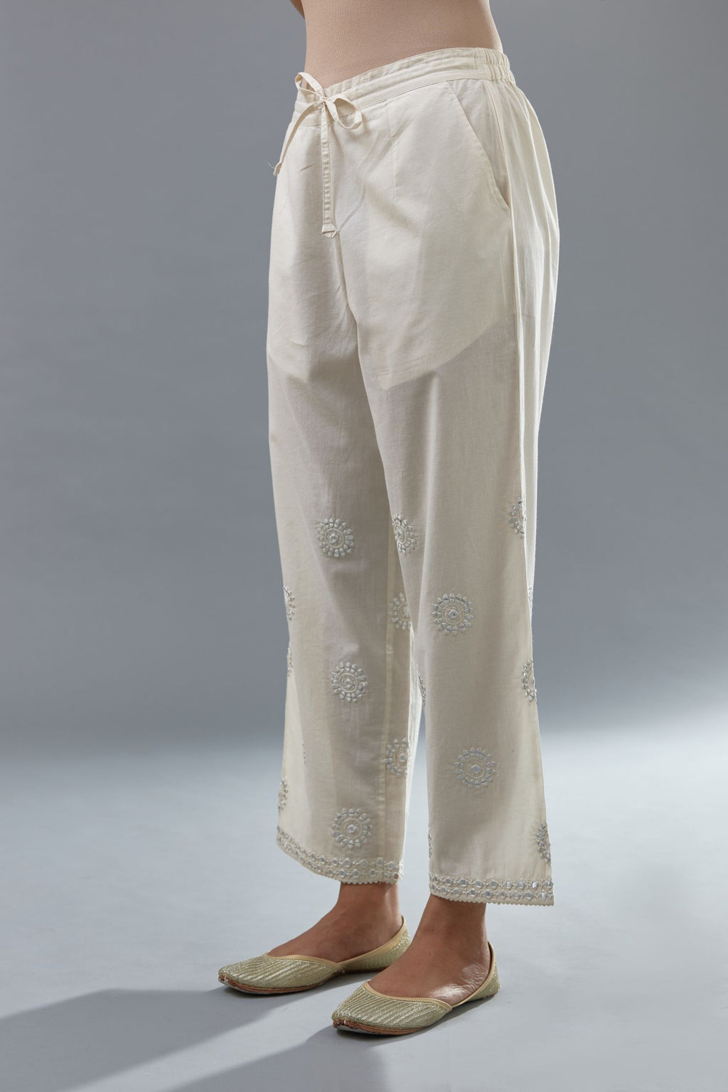 Off white cotton straight pants with all-over off white thread and mirror embroidery.