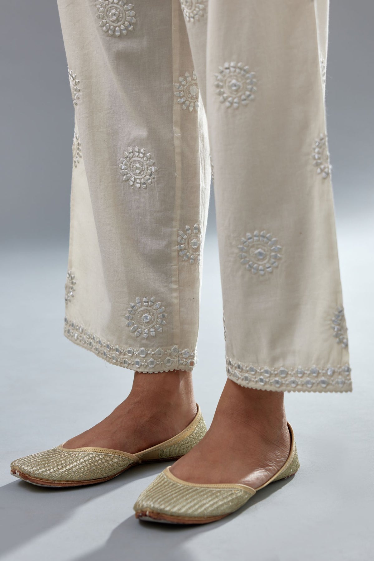 Off white cotton straight pants with all-over off white thread and mirror embroidery.