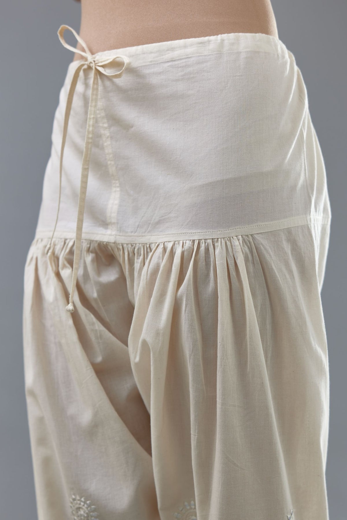 Off white cotton narrow salwar with all-over off white thread and mirror embroidery.