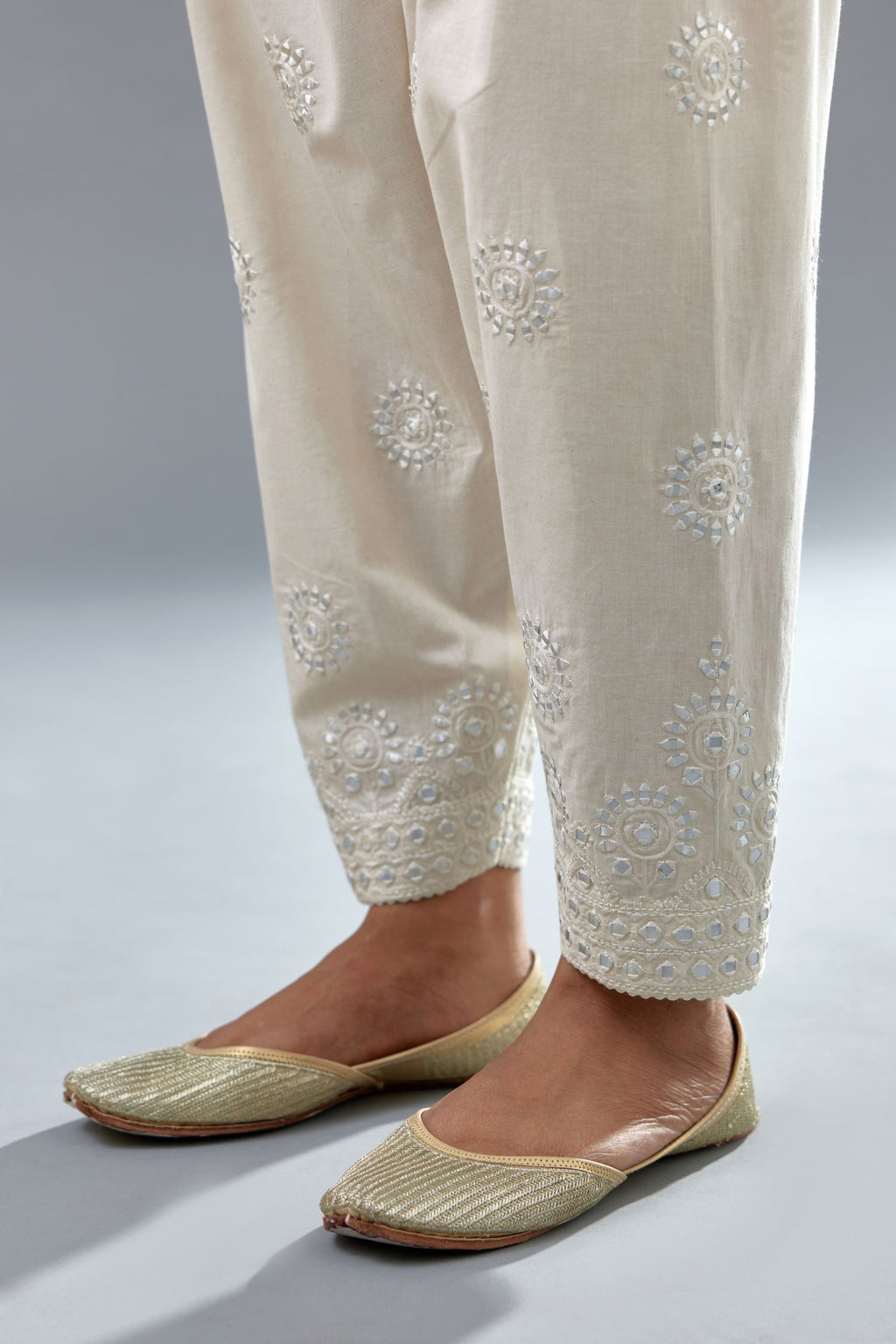 Off white cotton narrow salwar with all-over off white thread and mirror embroidery.