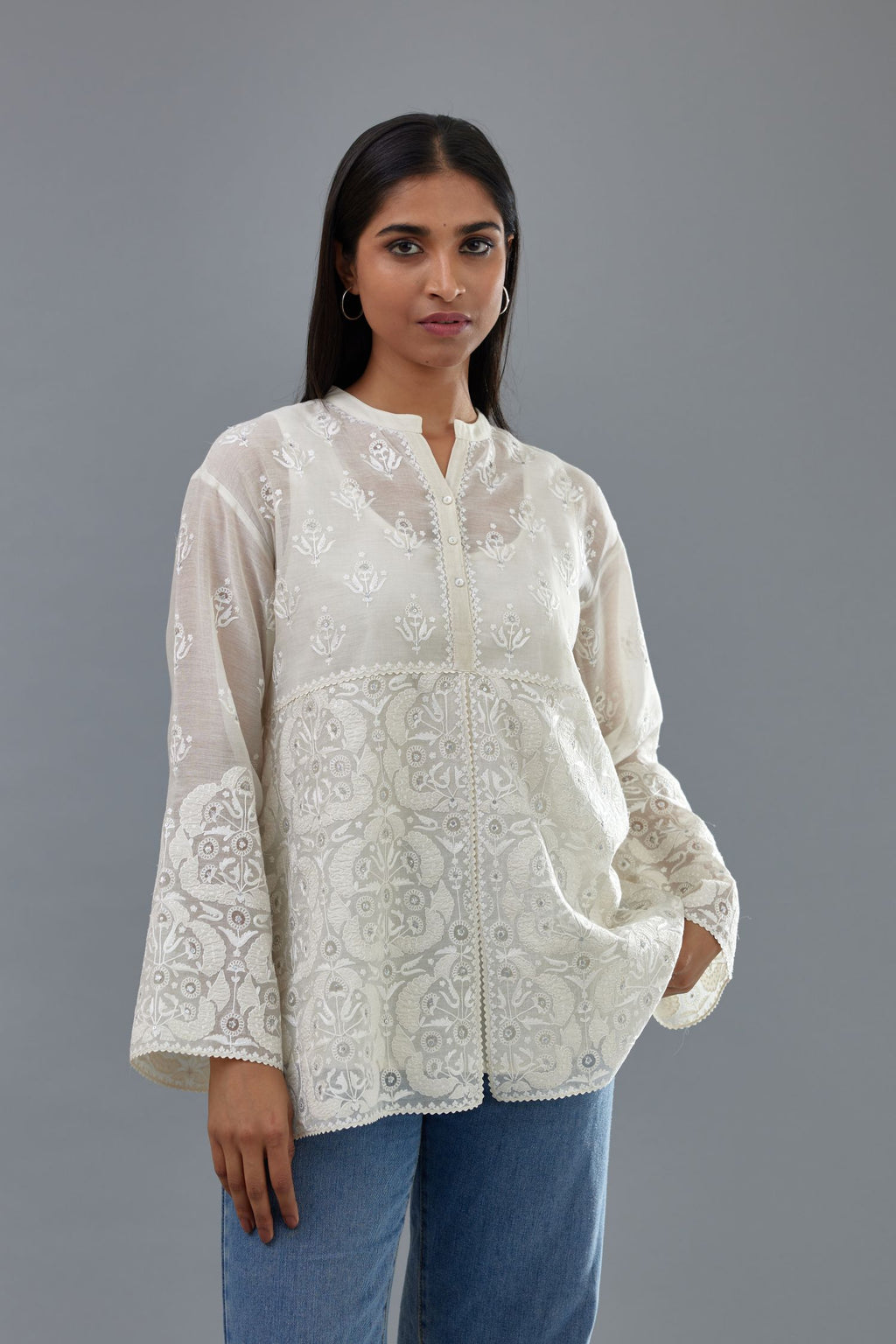 Off white cotton chanderi short top with heavy appliqué, highlighted with sequins, paired with off white cotton straight pants with appliqué and hand attached sequins detailing at bottom hem.