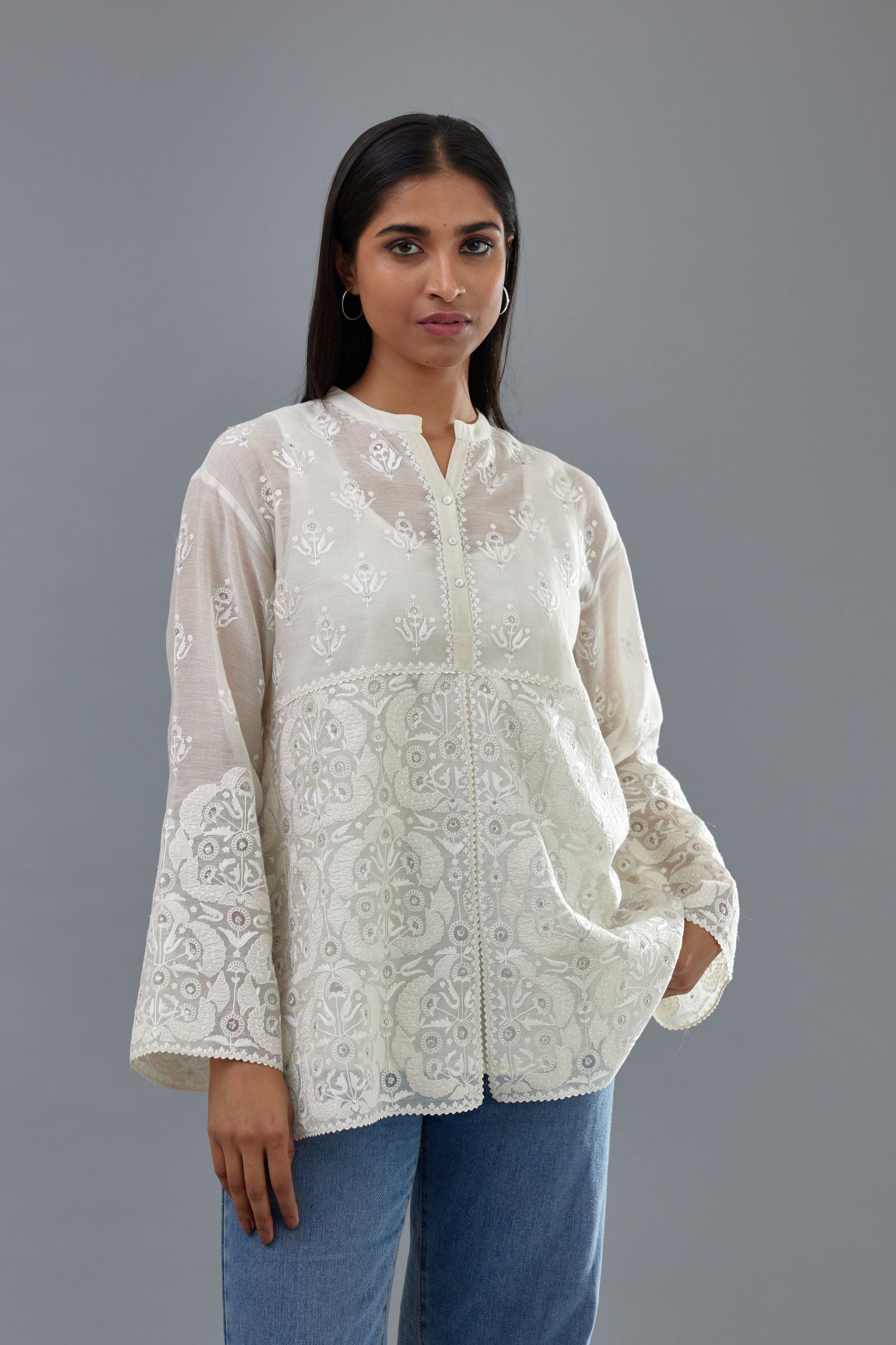 Off white cotton chanderi short top with heavy appliqué, highlighted with sequins, paired with off white cotton straight pants with appliqué and hand attached sequins detailing at bottom hem.