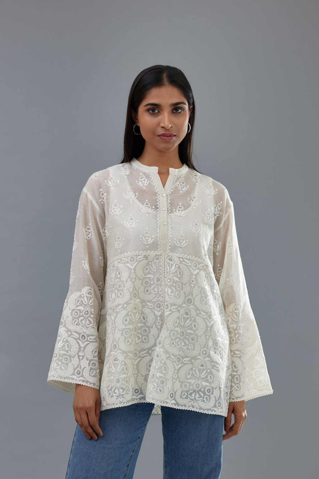 Off white cotton chanderi short top with heavy appliqué, highlighted with sequins, paired with off white cotton straight pants with appliqué and hand attached sequins detailing at bottom hem.