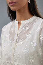 Off white cotton chanderi short top with heavy appliqué, highlighted with sequins, paired with off white cotton straight pants with appliqué and hand attached sequins detailing at bottom hem.
