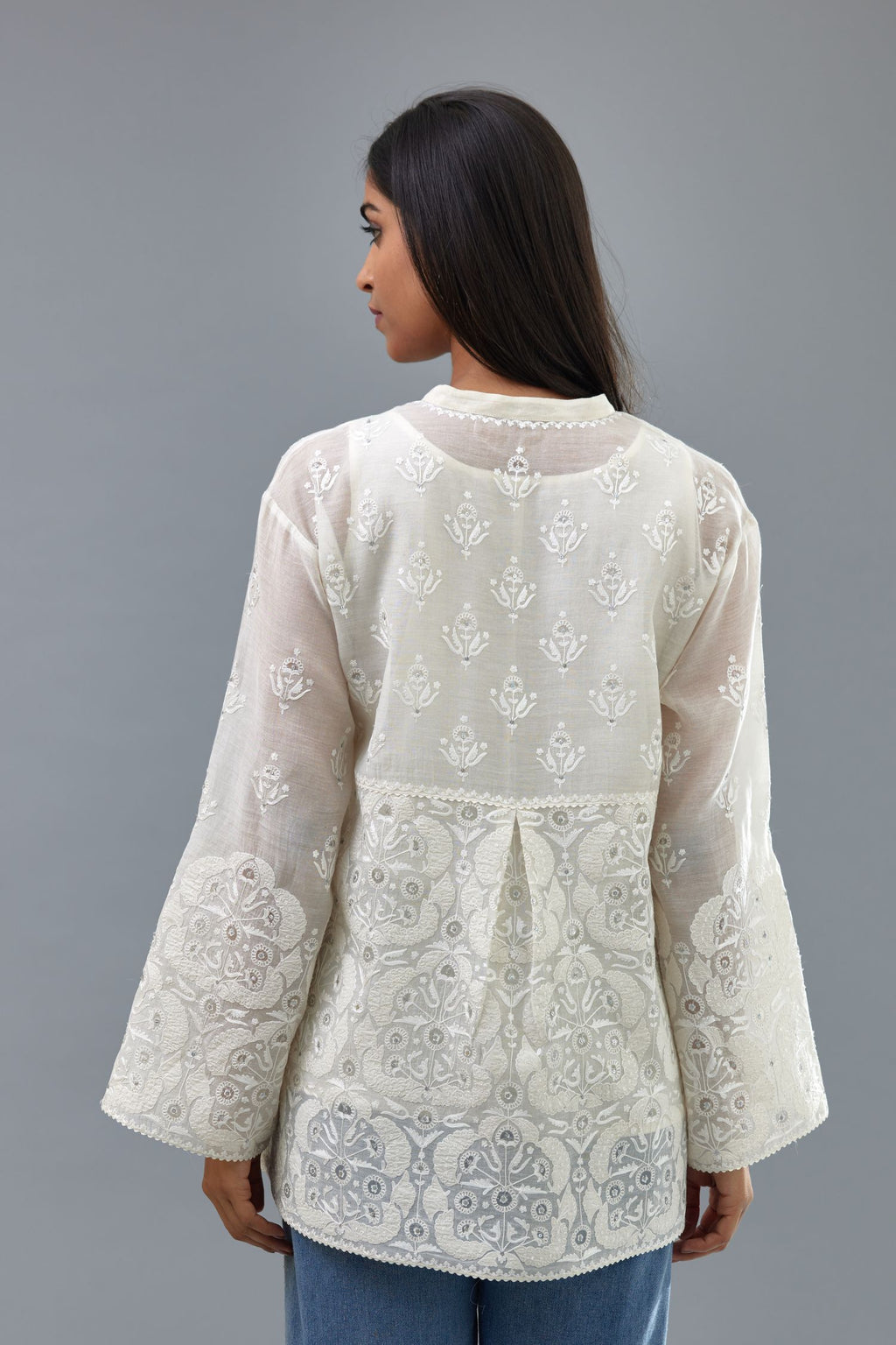 Off white cotton chanderi short top with heavy appliqué, highlighted with sequins, paired with off white cotton straight pants with appliqué and hand attached sequins detailing at bottom hem.