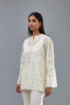 Off white cotton chanderi short top with heavy appliqué, highlighted with sequins, paired with off white cotton straight pants with appliqué and hand attached sequins detailing at bottom hem.
