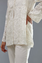 Off white cotton chanderi short top with heavy appliqué, highlighted with sequins, paired with off white cotton straight pants with appliqué and hand attached sequins detailing at bottom hem.