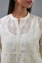 Off white cotton chanderi short top with heavy appliqué, highlighted with sequins, paired with off white cotton straight pants with appliqué and hand attached sequins detailing at bottom hem.