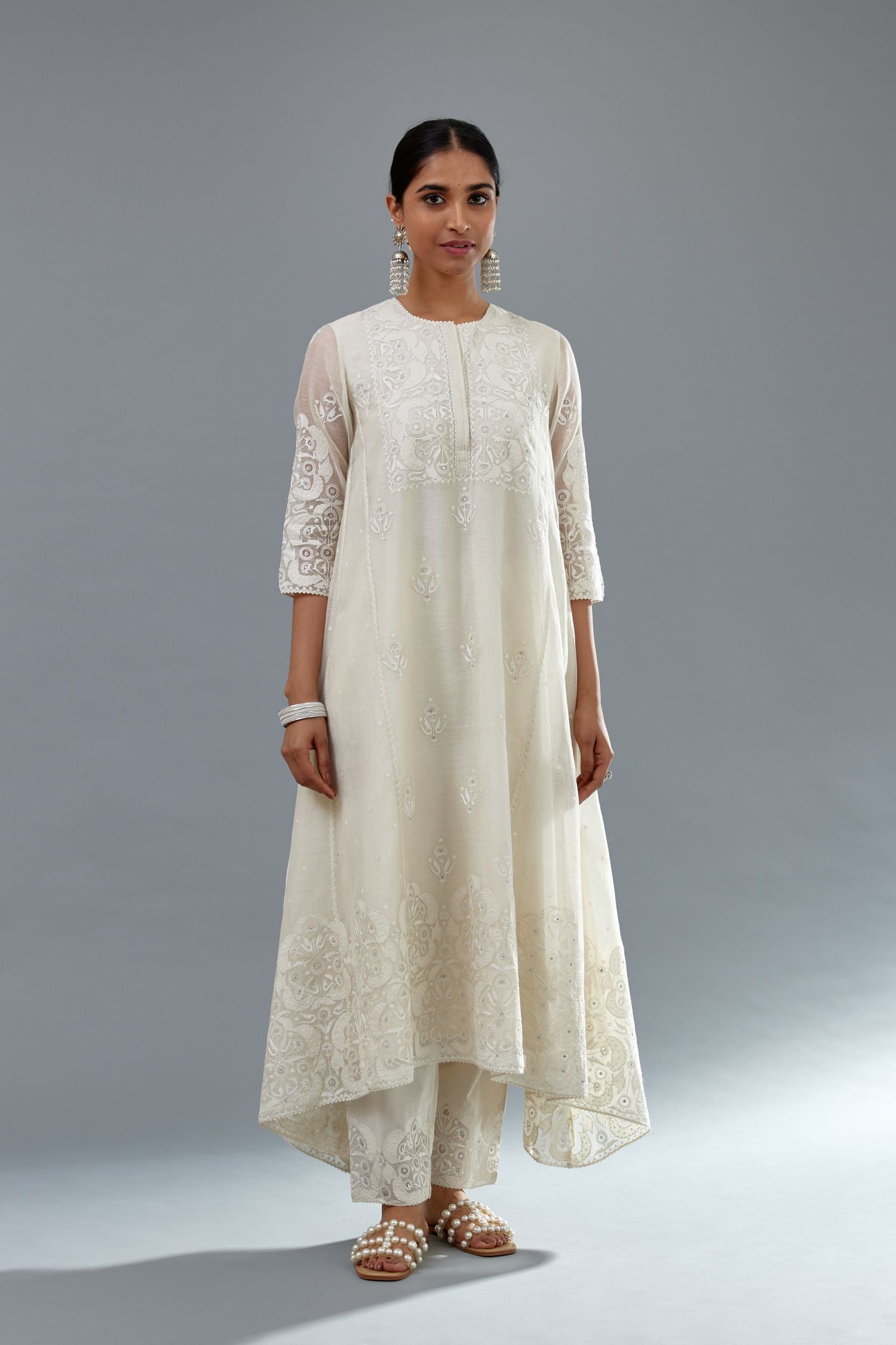 Off white A-line long kurta set with all-over tonal silk thread embroidery and cotton applique, highlighted with sequins work.