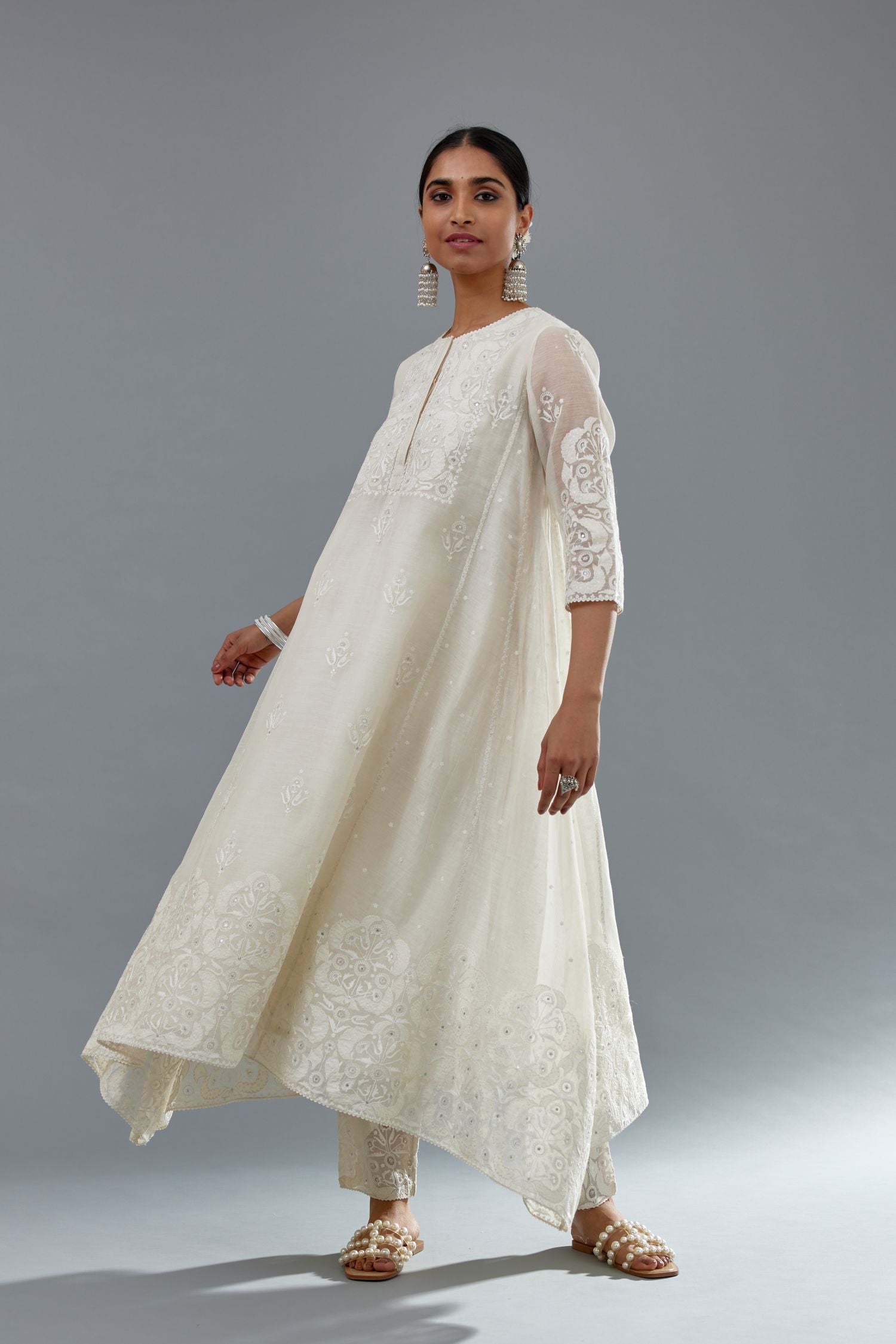Off white A-line long kurta set with all-over tonal silk thread embroidery and cotton applique, highlighted with sequins work.