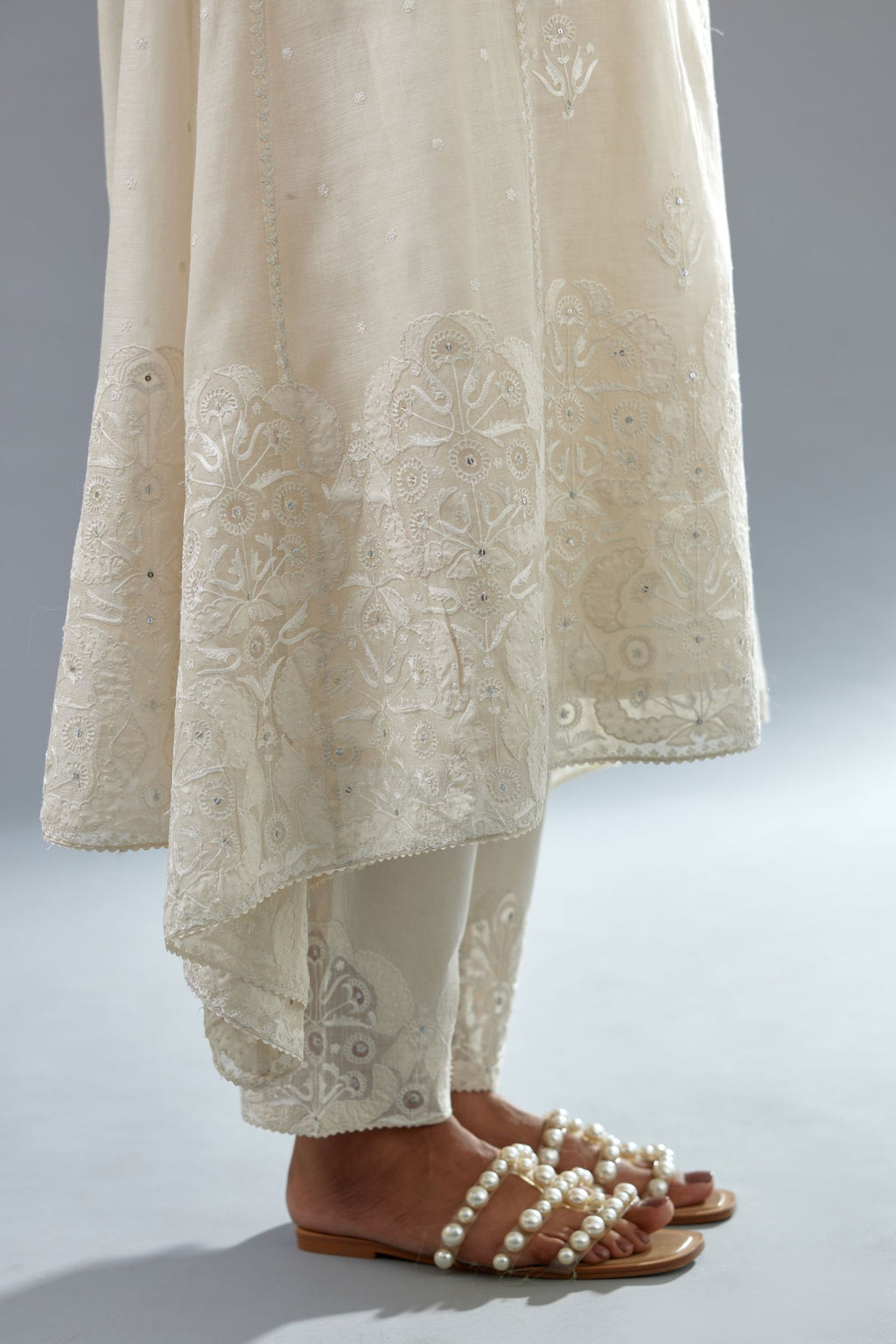 Off white A-line long kurta set with all-over tonal silk thread embroidery and cotton applique, highlighted with sequins work.