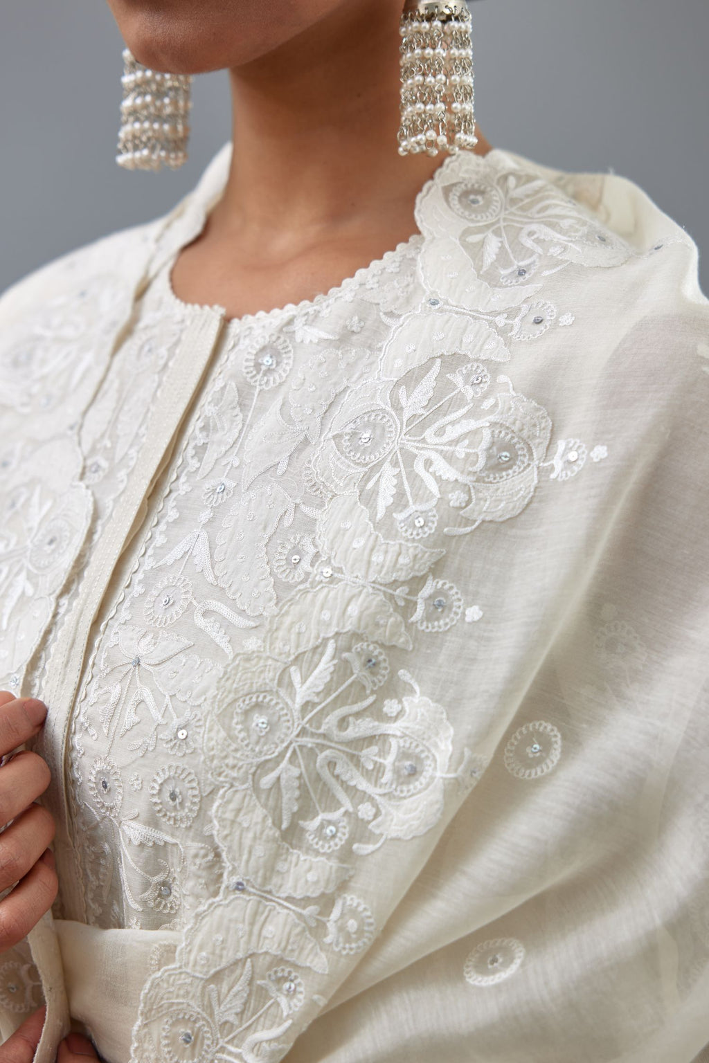 Off white A-line long kurta set with all-over tonal silk thread embroidery and cotton applique, highlighted with sequins work.