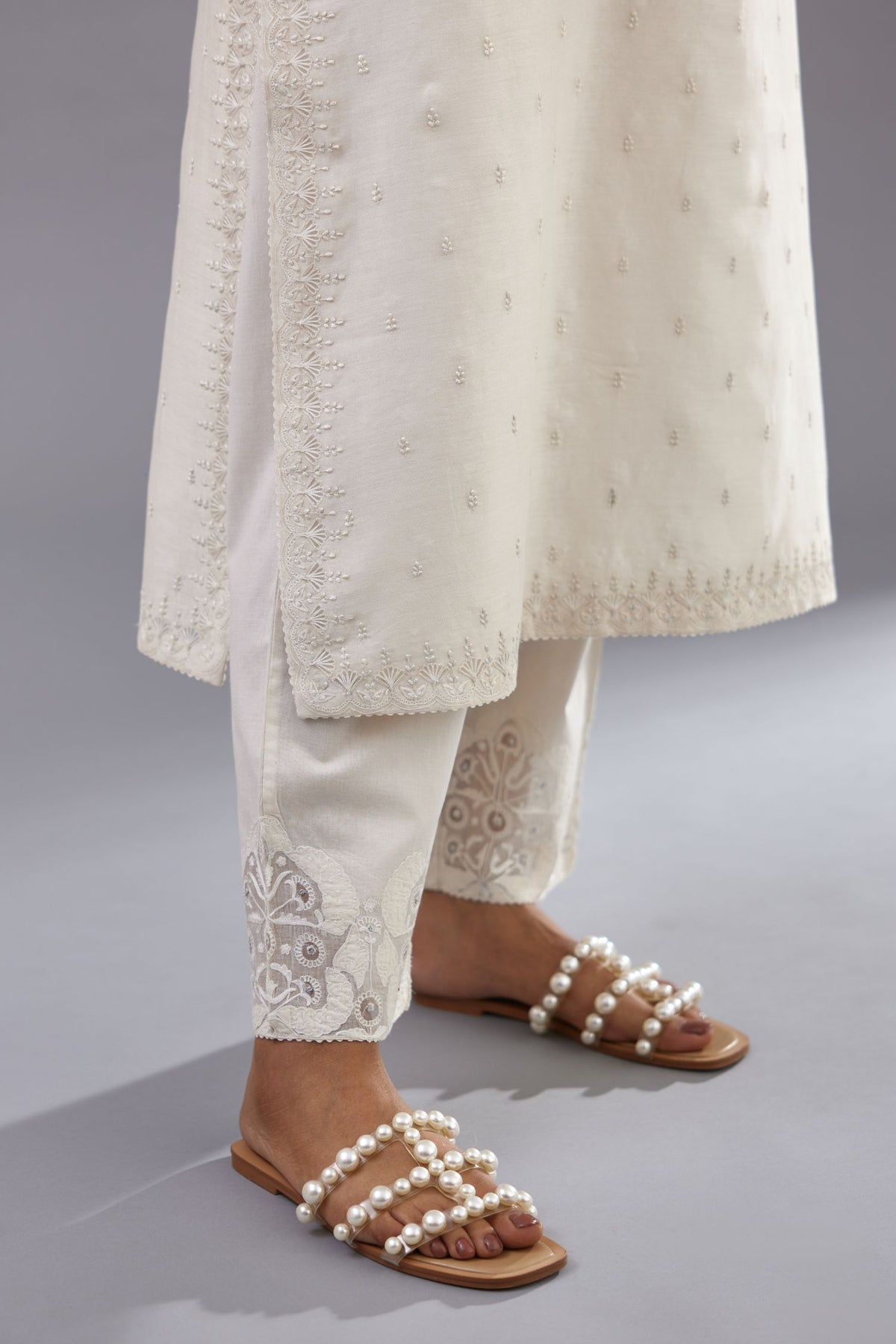 Off white silk chanderi straight kurta set with dori and silk thread embroidery at the neck, armholes, hem and sleeve cuffs.