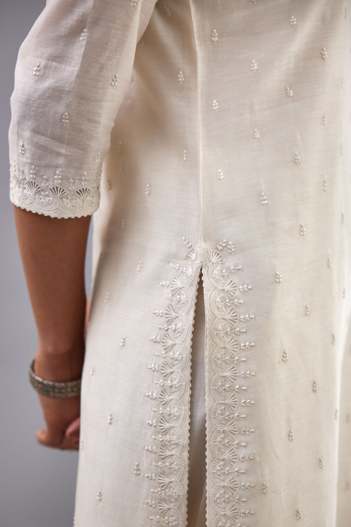 Off white silk chanderi straight kurta set with dori and silk thread embroidery at the neck, armholes, hem and sleeve cuffs.