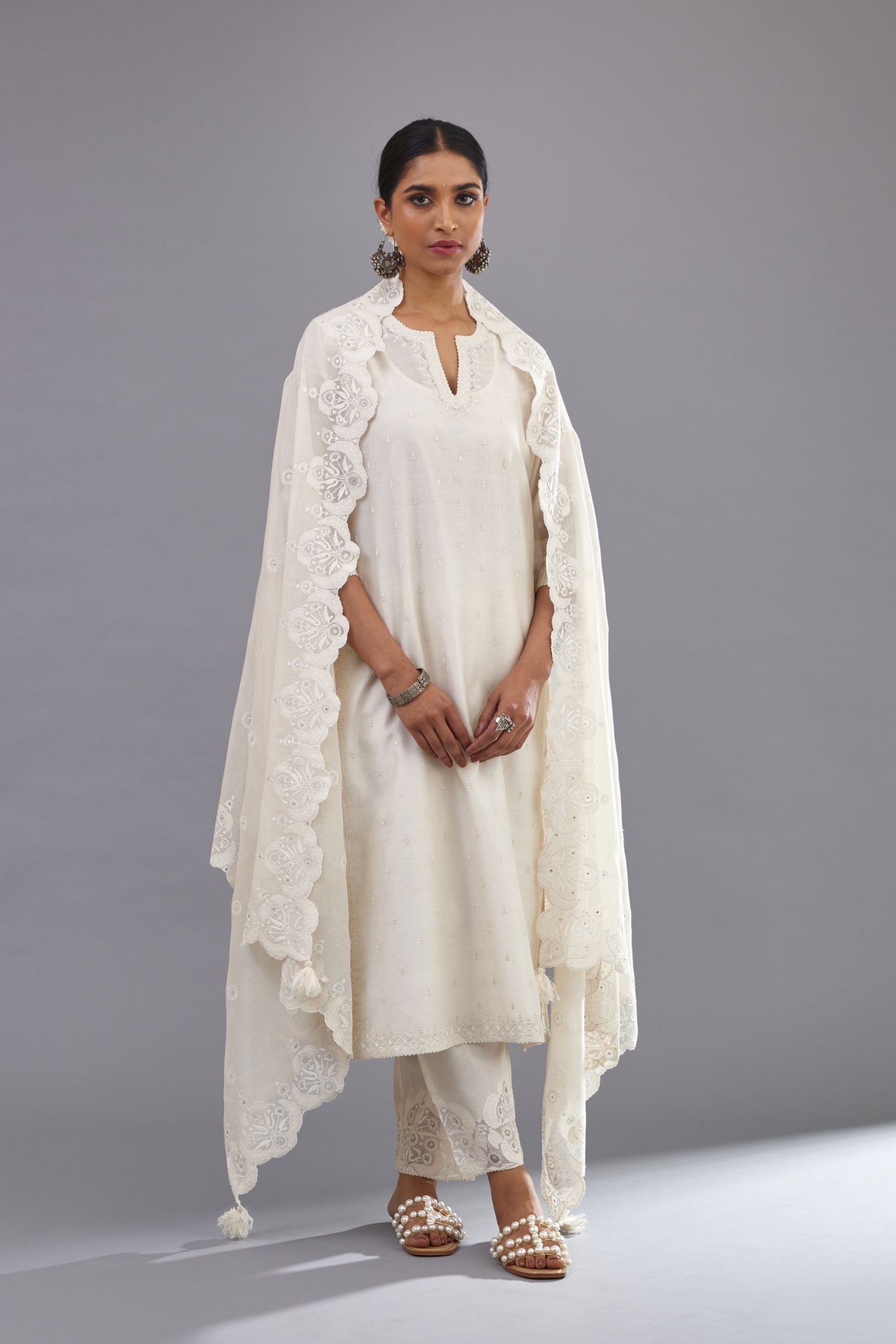 Off white silk chanderi straight kurta set with dori and silk thread embroidery at the neck, armholes, hem and sleeve cuffs.