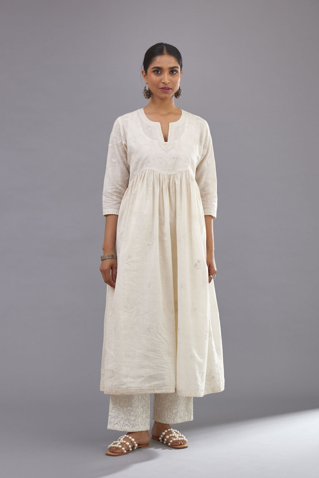 Handspun handwoven cotton  kurta set with wavy empire waistline and gathers, highlighted with all-over tonal colored thread embroidery and ric-rac detail.