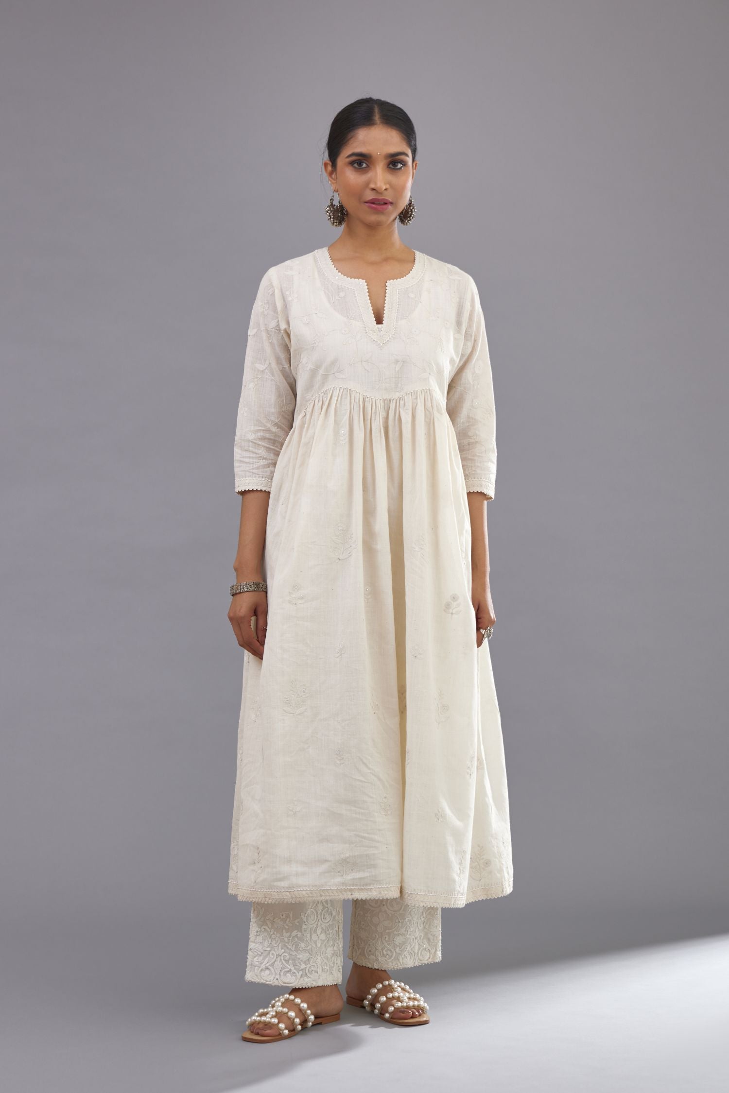 Handspun handwoven cotton  kurta set with wavy empire waistline and gathers, highlighted with all-over tonal colored thread embroidery and ric-rac detail.