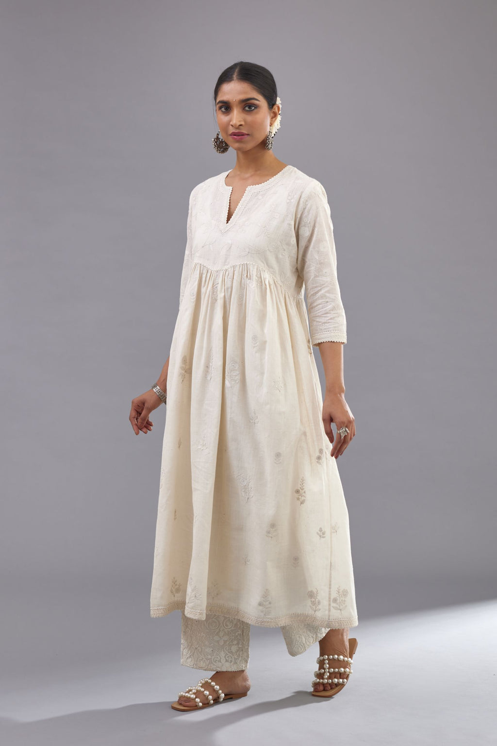 Handspun handwoven cotton  kurta set with wavy empire waistline and gathers, highlighted with all-over tonal colored thread embroidery and ric-rac detail.