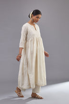 Handspun handwoven cotton  kurta set with wavy empire waistline and gathers, highlighted with all-over tonal colored thread embroidery and ric-rac detail.