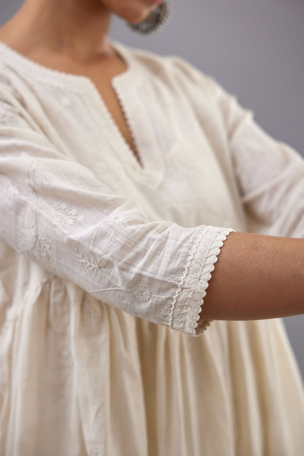 Handspun handwoven cotton  kurta set with wavy empire waistline and gathers, highlighted with all-over tonal colored thread embroidery and ric-rac detail.