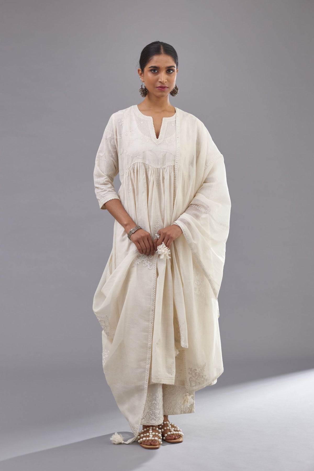 Handspun handwoven cotton  kurta set with wavy empire waistline and gathers, highlighted with all-over tonal colored thread embroidery and ric-rac detail.