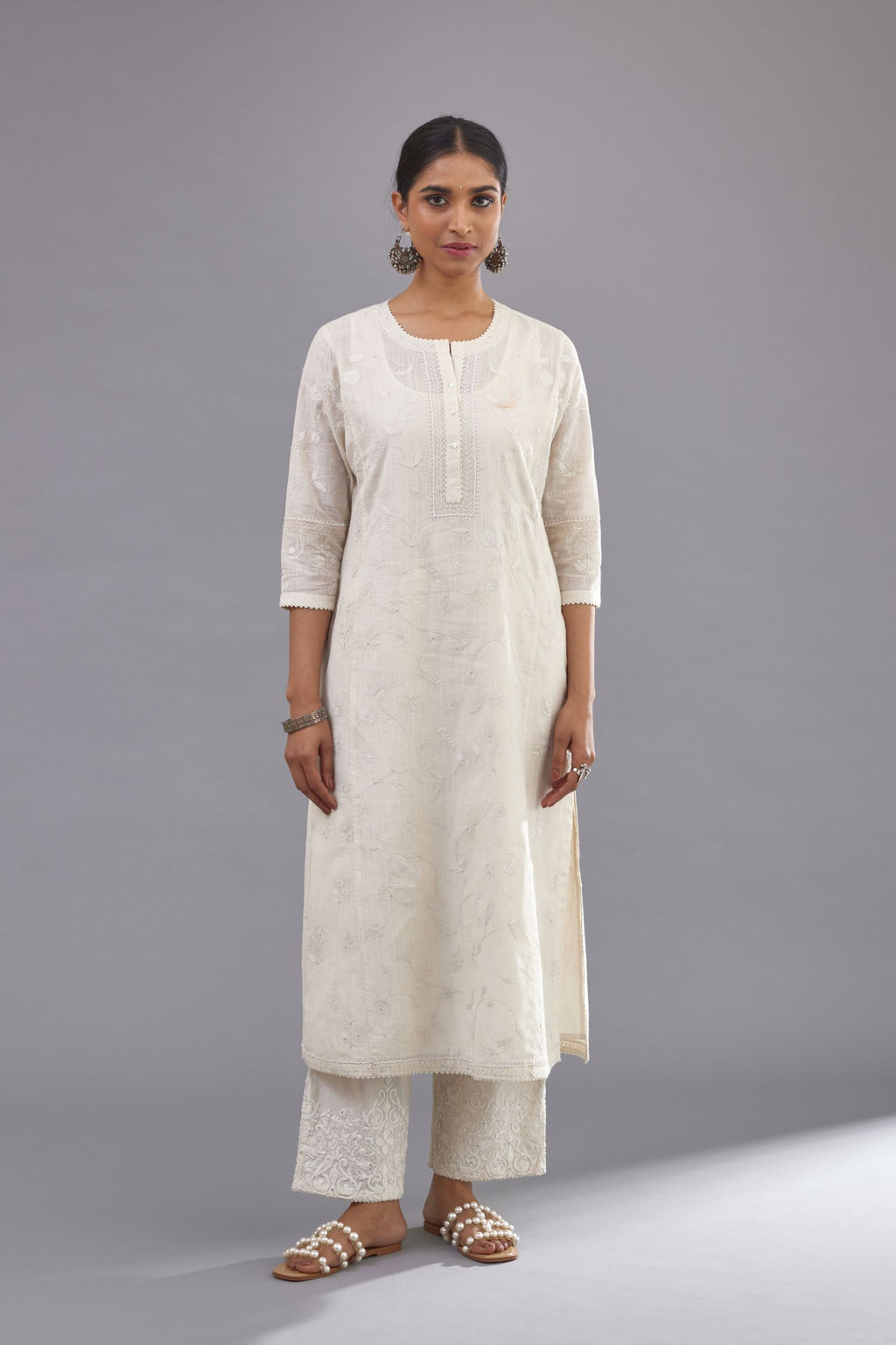 Off-white Handspun handwoven cotton kurta set with all-over jaal embroidery and small assorted flowers embroidery at side panells, highlighted with sequins handwork.
