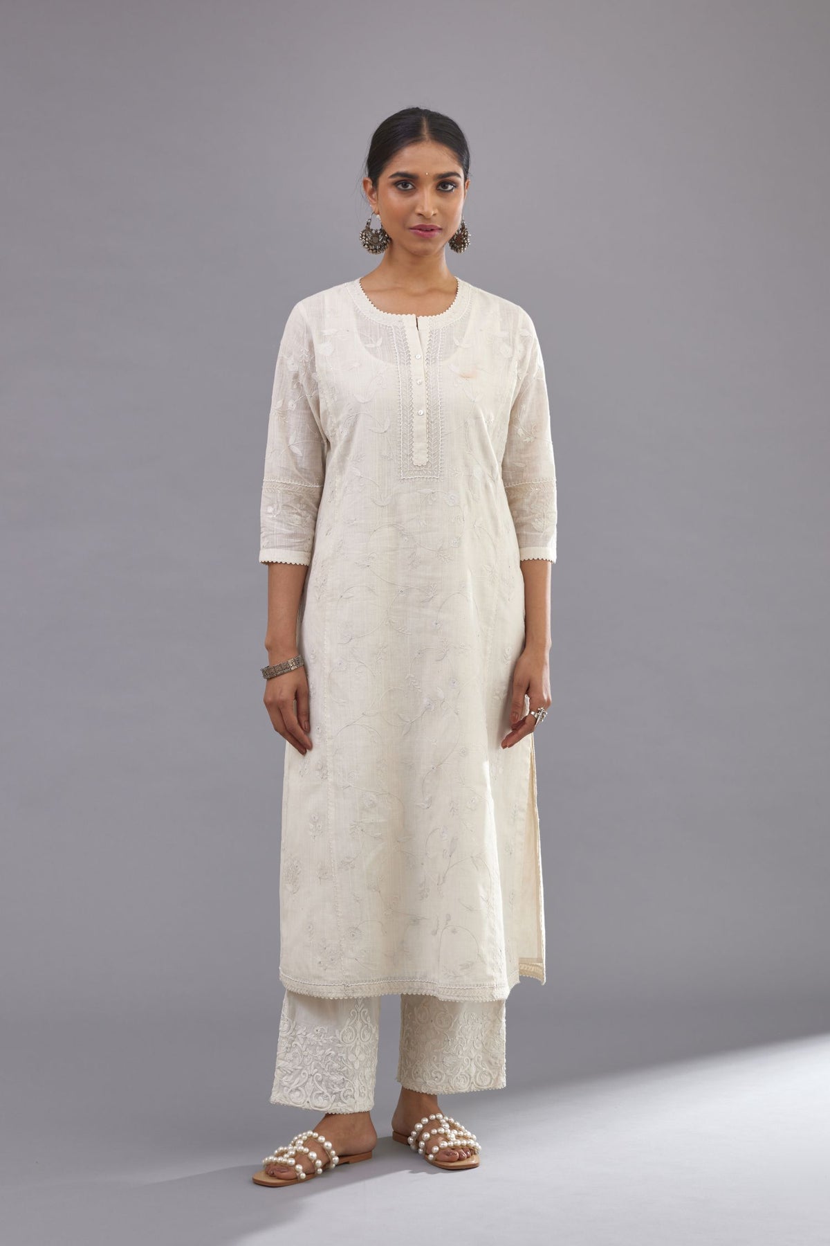 Off-white Handspun handwoven cotton kurta set with all-over jaal embroidery and small assorted flowers embroidery at side panells, highlighted with sequins handwork.