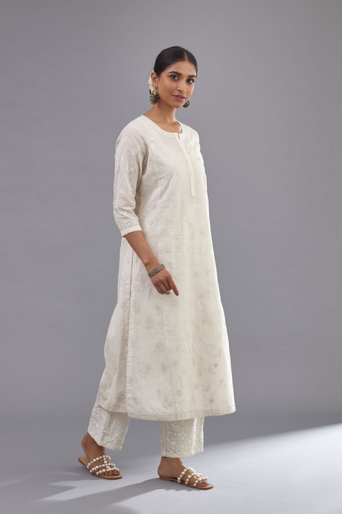Off-white Handspun handwoven cotton kurta set with all-over jaal embroidery and small assorted flowers embroidery at side panells, highlighted with sequins handwork.