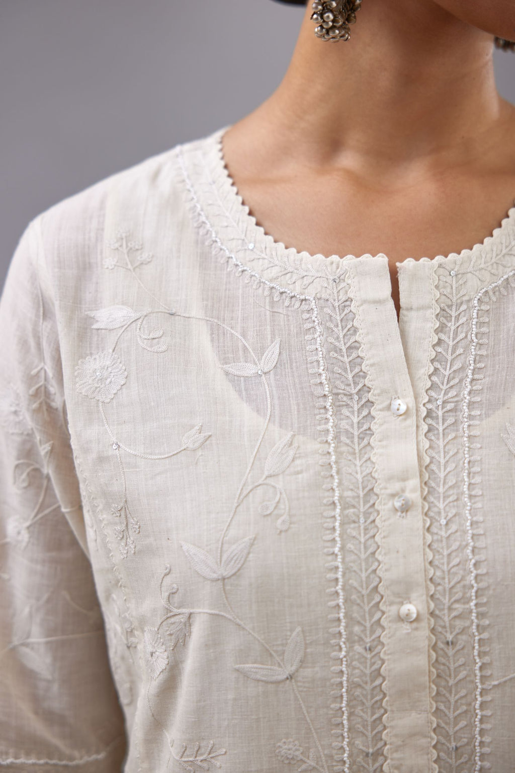 Off-white Handspun handwoven cotton kurta set with all-over jaal embroidery and small assorted flowers embroidery at side panells, highlighted with sequins handwork.