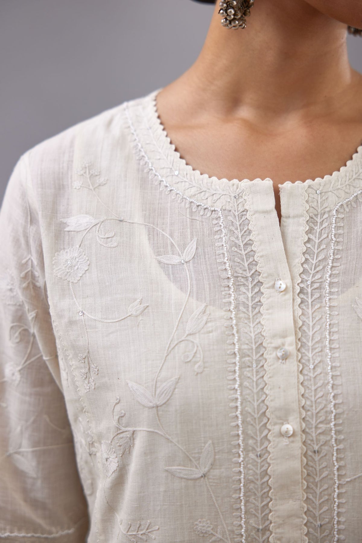 Off-white Handspun handwoven cotton kurta set with all-over jaal embroidery and small assorted flowers embroidery at side panells, highlighted with sequins handwork.