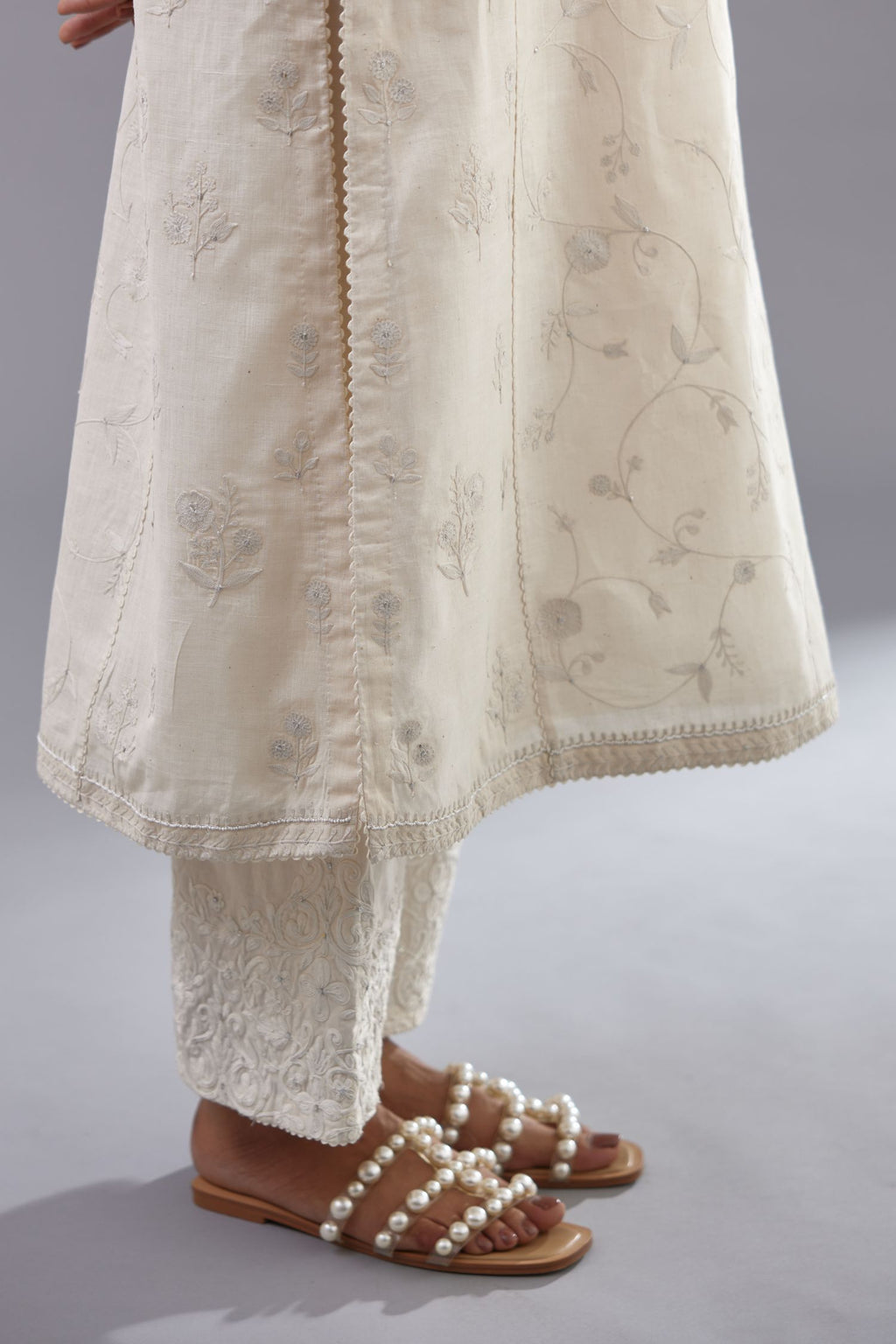 Off-white Handspun handwoven cotton kurta set with all-over jaal embroidery and small assorted flowers embroidery at side panells, highlighted with sequins handwork.