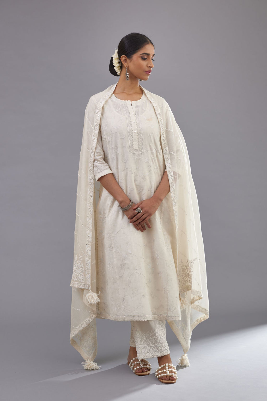 Off-white Handspun handwoven cotton kurta set with all-over jaal embroidery and small assorted flowers embroidery at side panells, highlighted with sequins handwork.