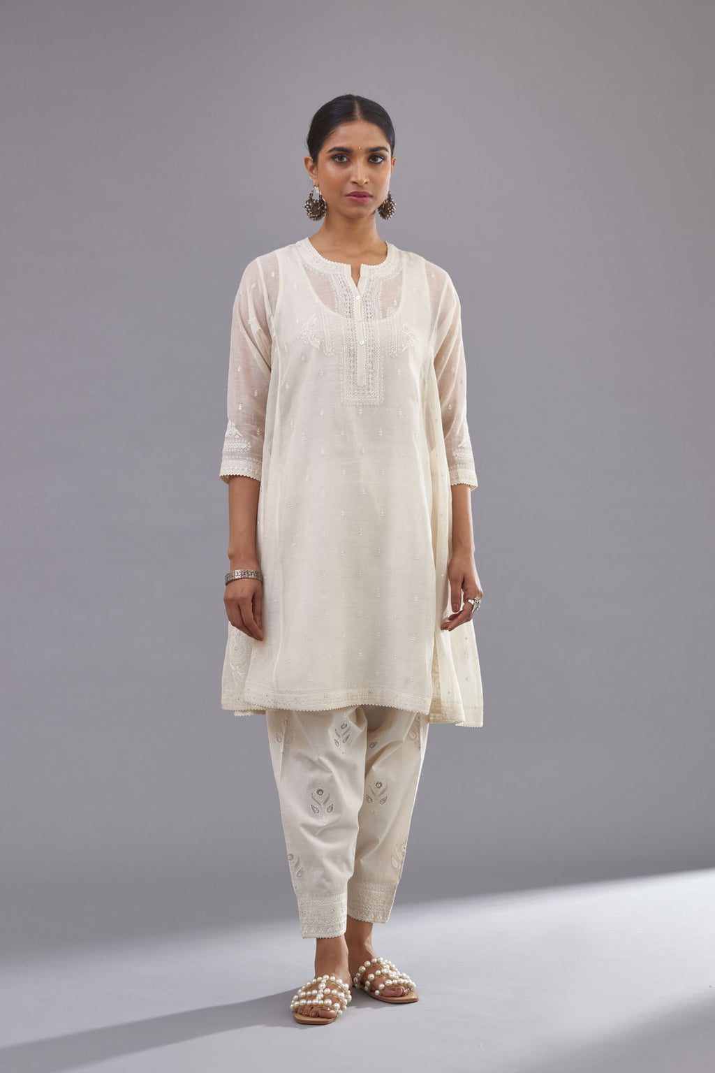 Off white cotton chanderi short kalidar phiran style kurta set with button placket neckline and dori and silk thraed embroidery all over.