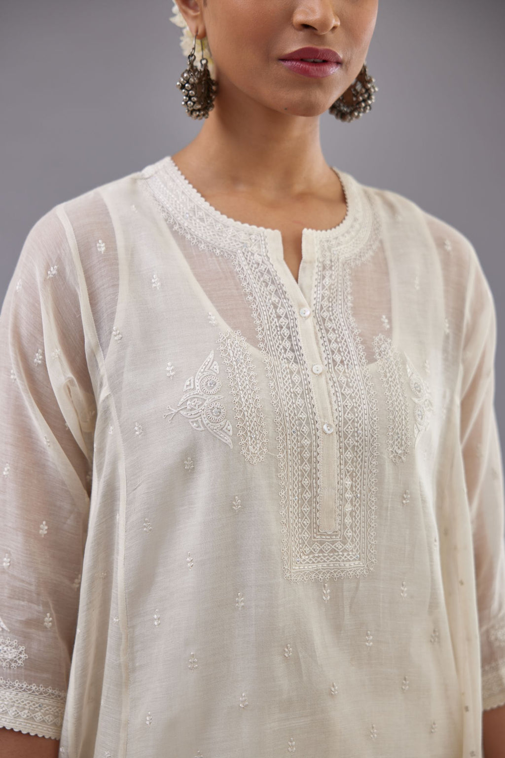 Off white cotton chanderi short kalidar phiran style kurta set with button placket neckline and dori and silk thraed embroidery all over.