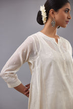 Off white cotton chanderi short kalidar phiran style kurta set with button placket neckline and dori and silk thraed embroidery all over.