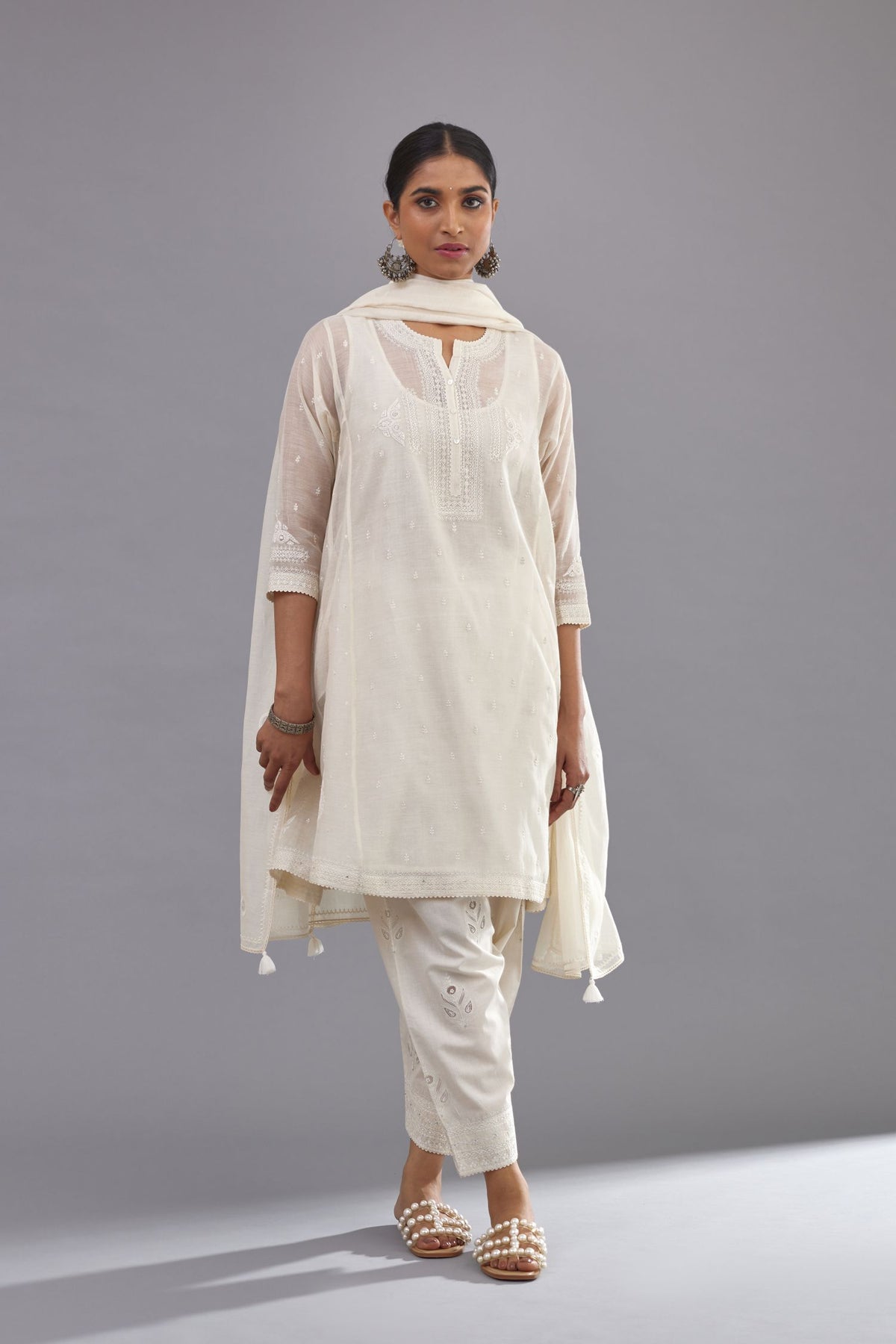 Off white cotton chanderi short kalidar phiran style kurta set with button placket neckline and dori and silk thraed embroidery all over.