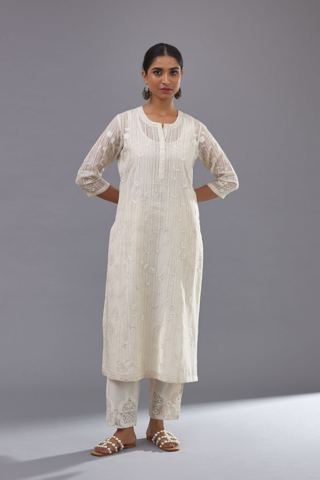 Off-white cotton chanderi kurta set with all-over jaal embroidery and small assorted flowers embroidery at side panells, highlighted with sequins handwork.