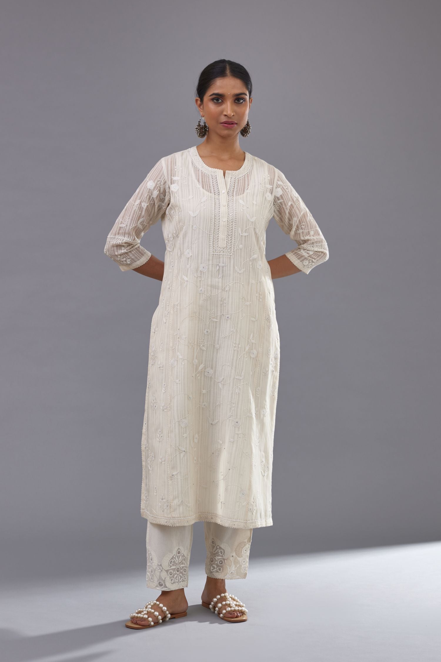 Off-white cotton chanderi kurta set with all-over jaal embroidery and small assorted flowers embroidery at side panells, highlighted with sequins handwork.