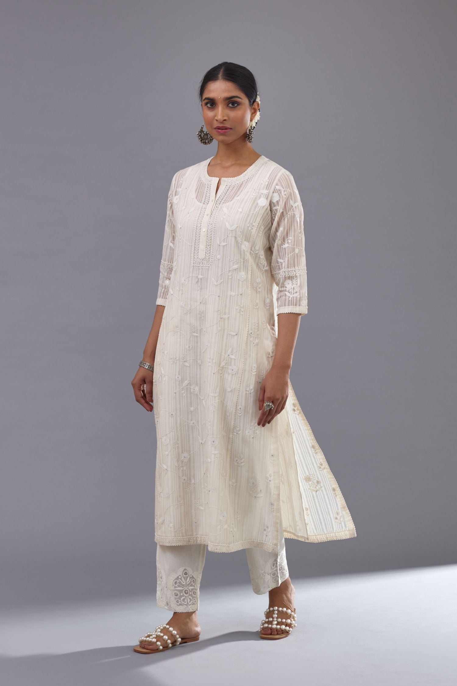 Off-white cotton chanderi kurta set with all-over jaal embroidery and small assorted flowers embroidery at side panells, highlighted with sequins handwork.