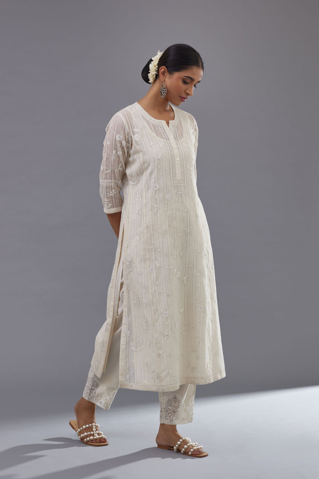 Off-white cotton chanderi kurta set with all-over jaal embroidery and small assorted flowers embroidery at side panells, highlighted with sequins handwork.