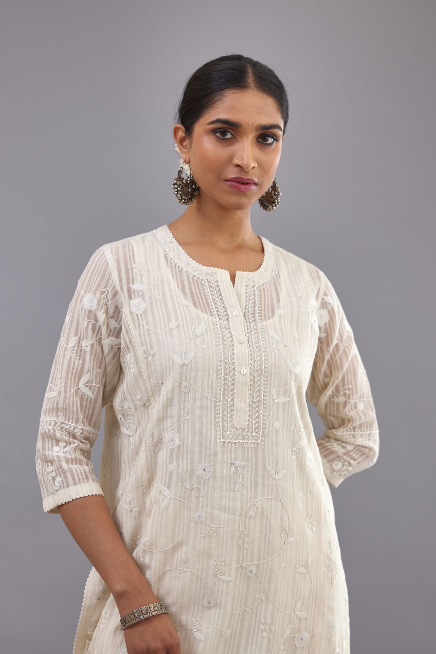 Off-white cotton chanderi kurta set with all-over jaal embroidery and small assorted flowers embroidery at side panells, highlighted with sequins handwork.