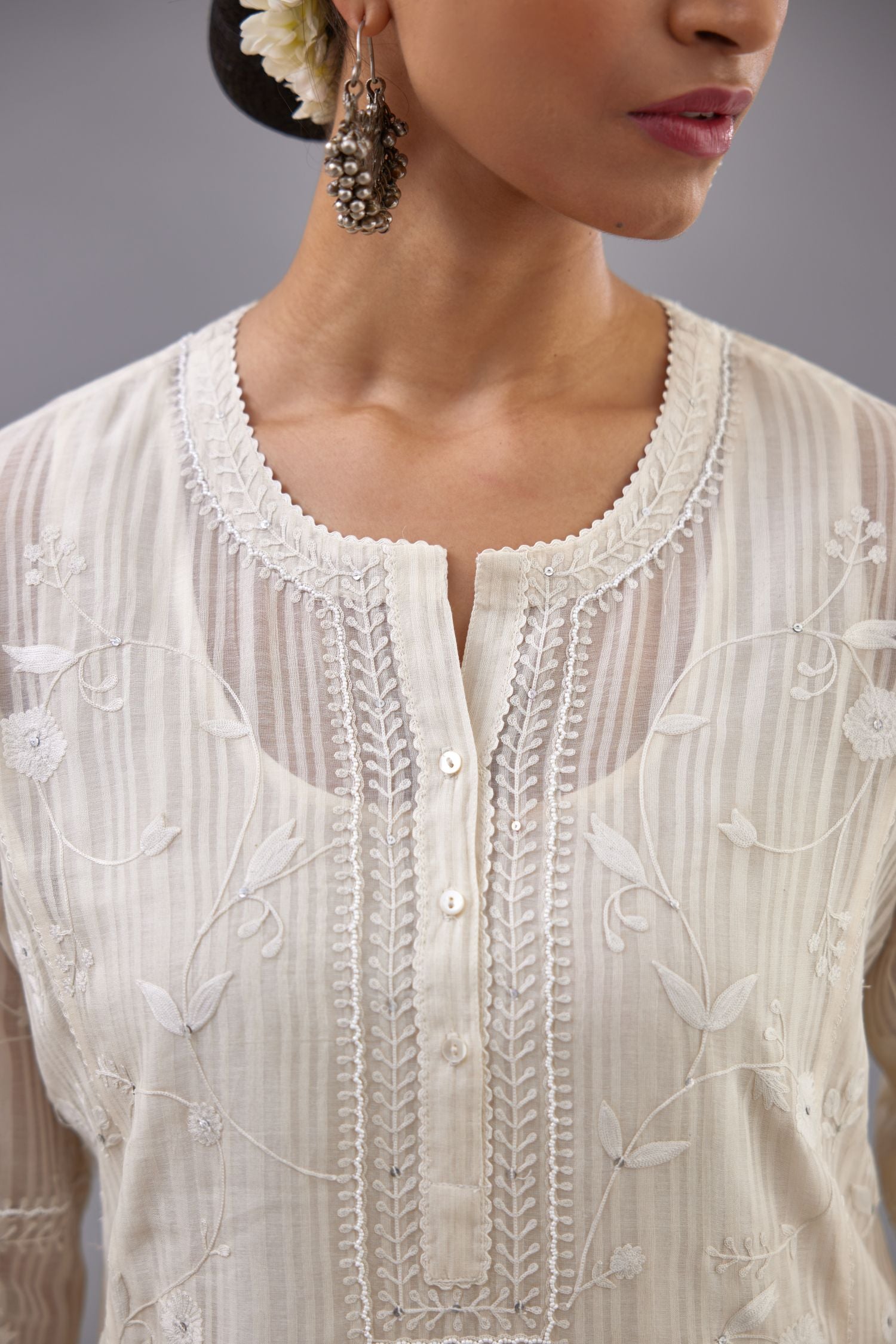 Off-white cotton chanderi kurta set with all-over jaal embroidery and small assorted flowers embroidery at side panells, highlighted with sequins handwork.