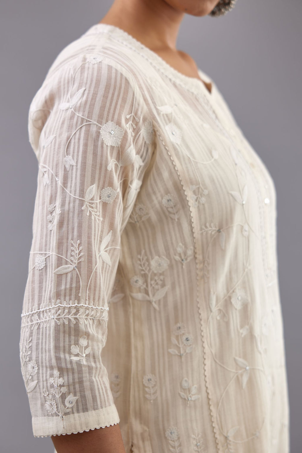 Off-white cotton chanderi kurta set with all-over jaal embroidery and small assorted flowers embroidery at side panells, highlighted with sequins handwork.