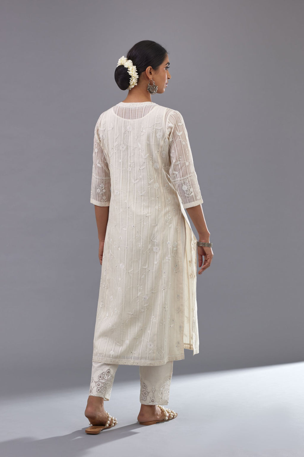 Off-white cotton chanderi kurta set with all-over jaal embroidery and small assorted flowers embroidery at side panells, highlighted with sequins handwork.
